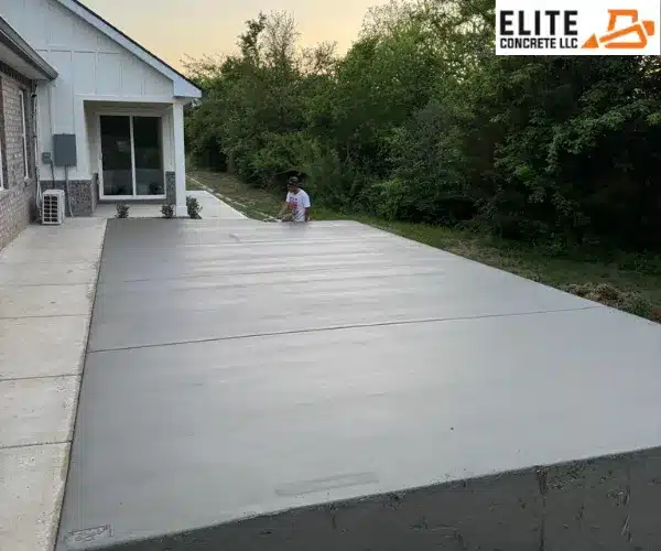 A wide view of the newly leveled concrete slab patio stretching into the backyard of a house