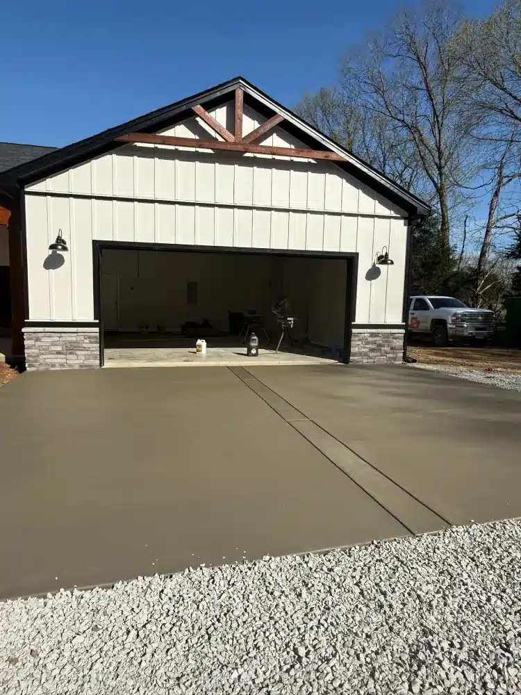 Spacious modern detached garage with a wide concrete driveway constructed by a garage builder.